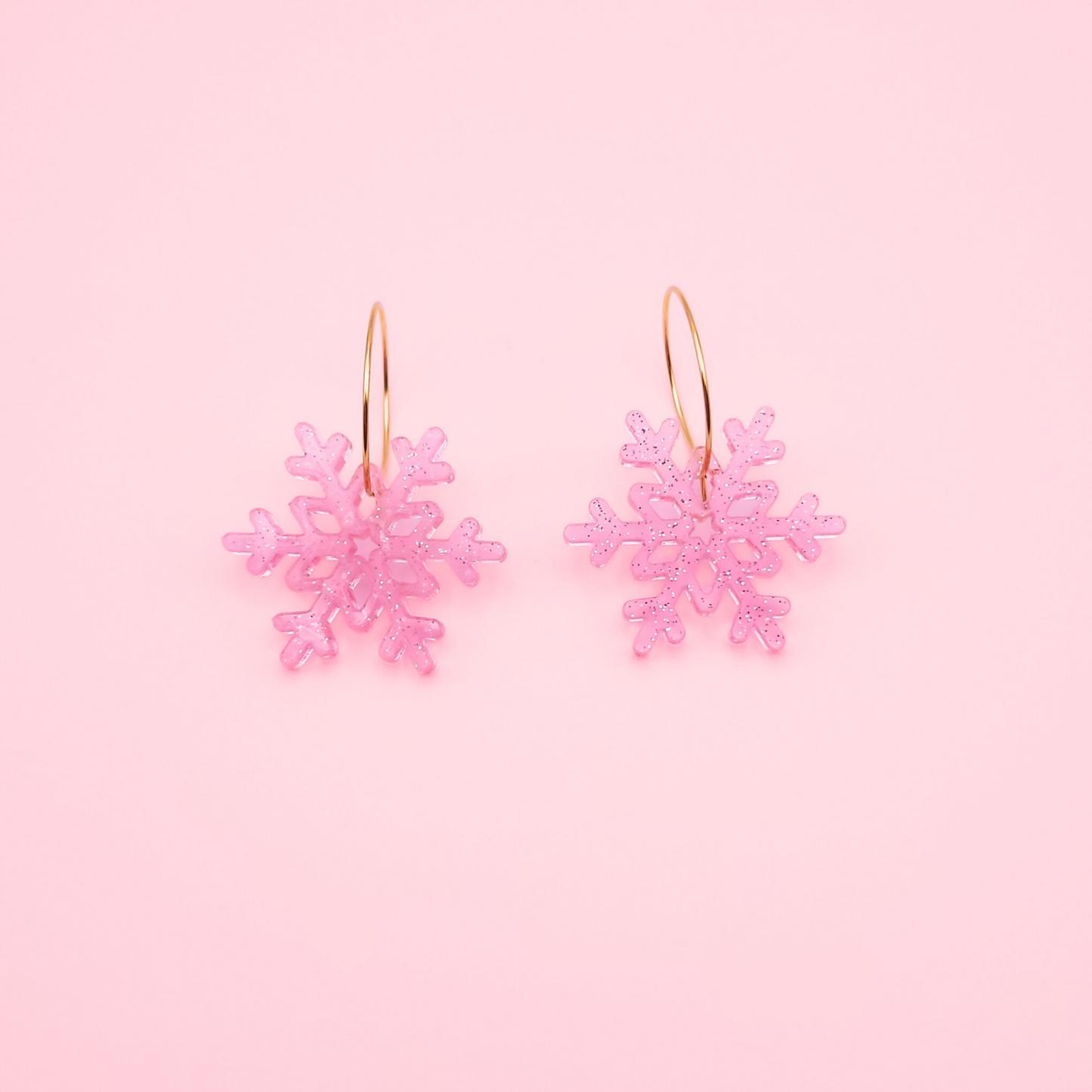 Pink glitter acrylic snowflake earrings on gold hoops — handmade cute winter dangle earrings.