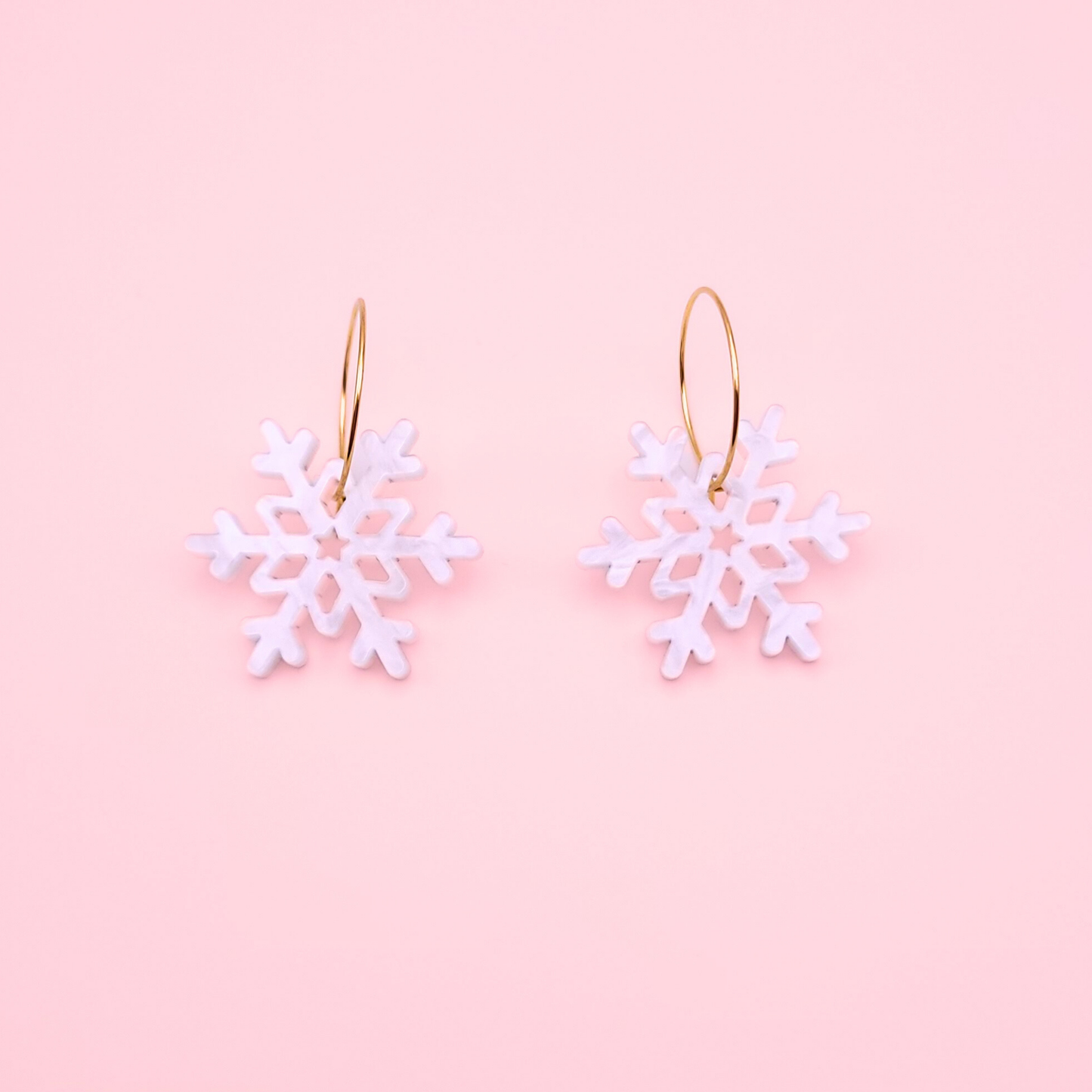 White marble acrylic snowflake earrings on gold hoops — handmade winter dangle earrings.