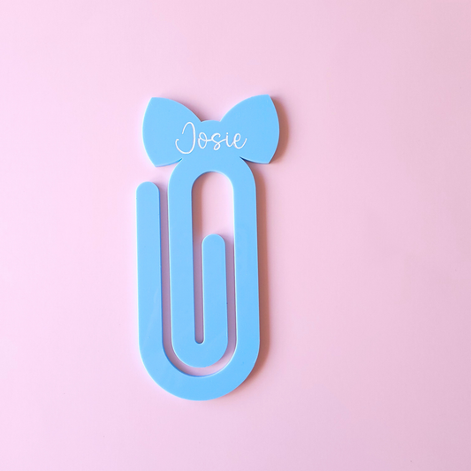 Blue acrylic bow bookmark with custom name Josie in white text on pastel background
