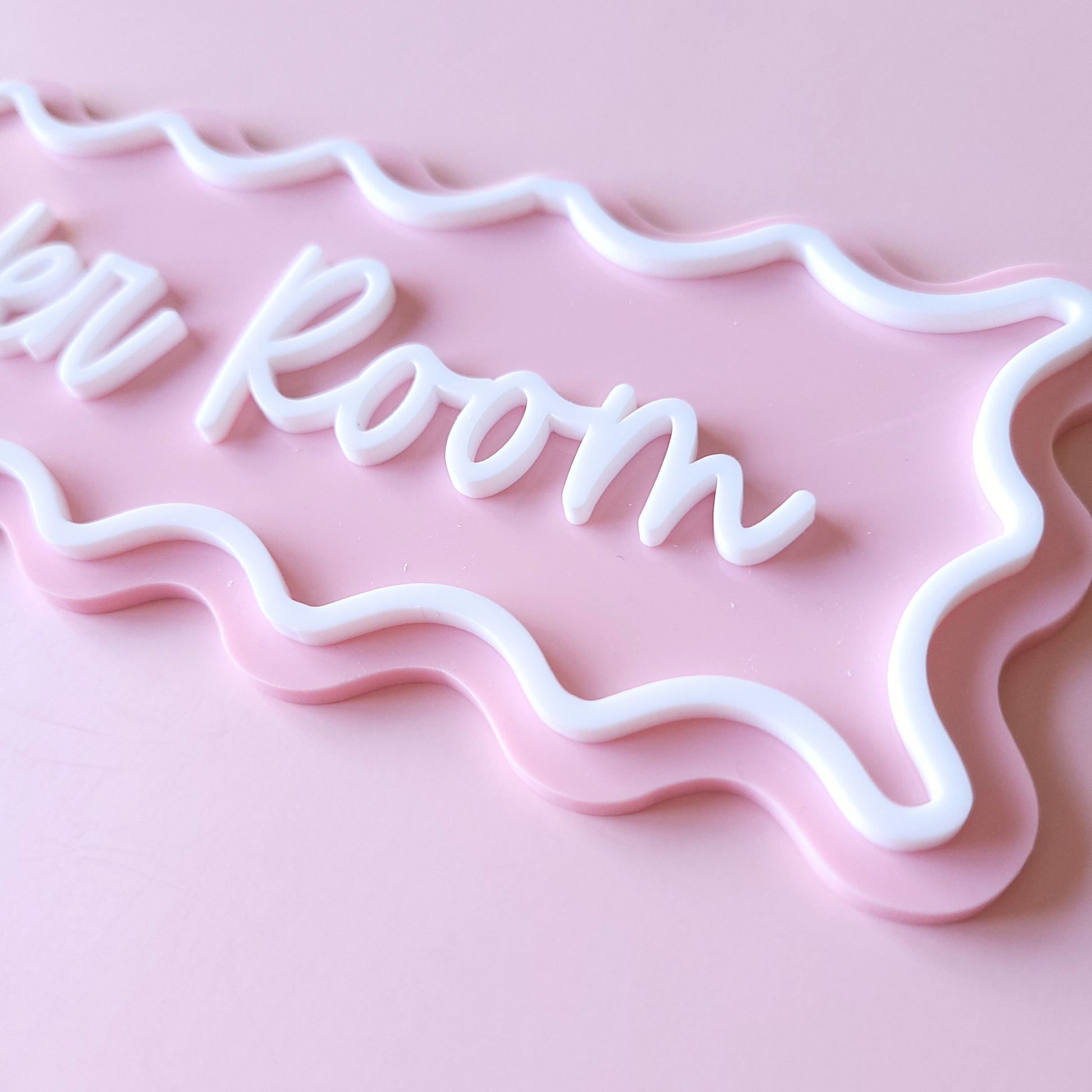 Modern acrylic bathroom door sign in pink pastel with wavy frame