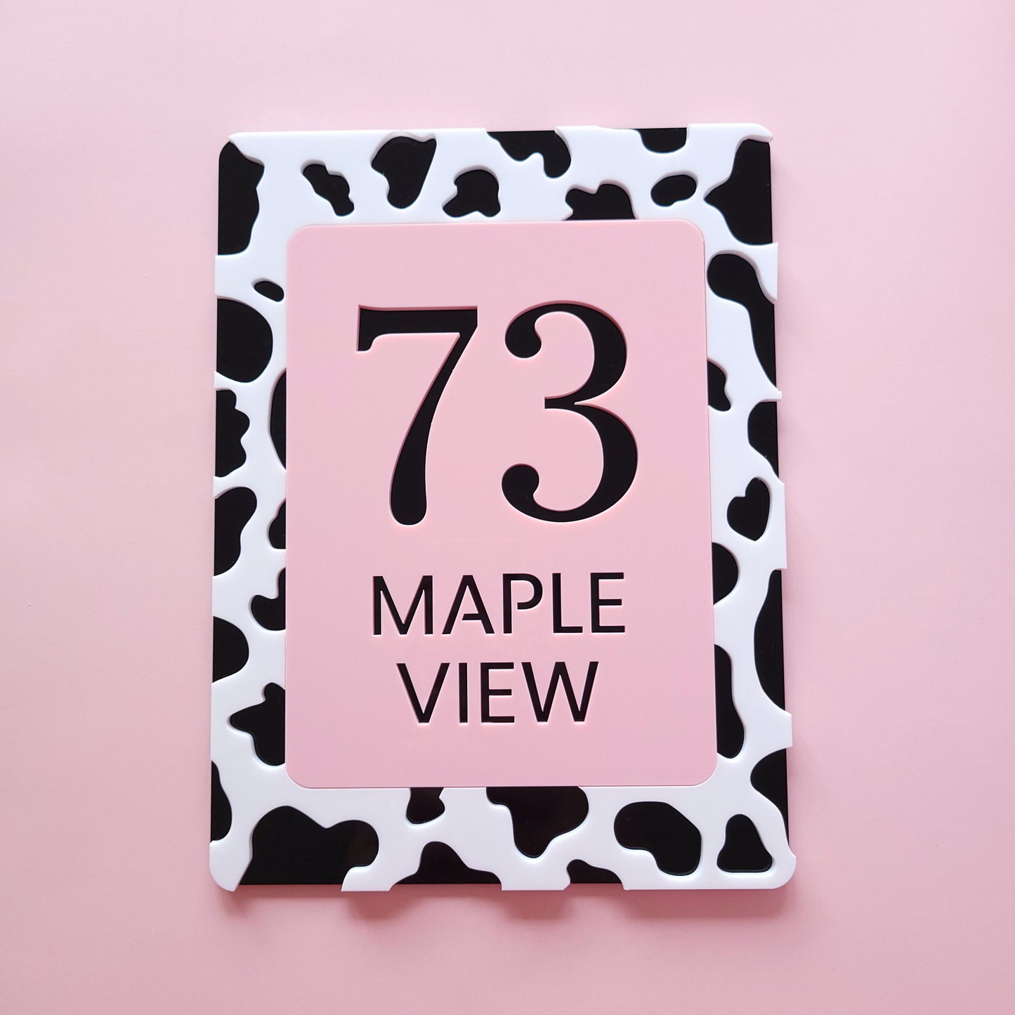 Custom cow print house number sign in pastel pink and black acrylic, handmade in Ireland