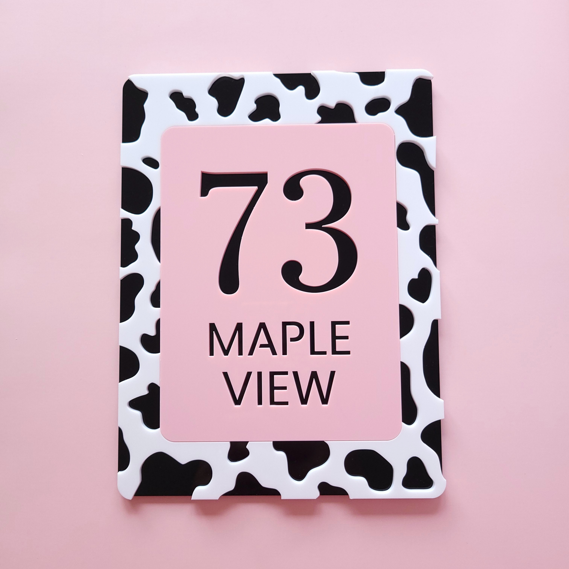 Custom cow print house number sign in pastel pink and black acrylic, handmade in Ireland