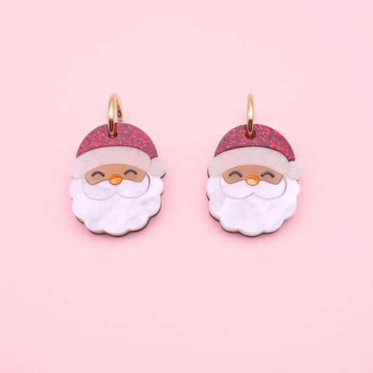 Cute acrylic Santa earrings with glitter red hats, pearly white beards, and shiny mirror noses on gold hoops — festive Christmas jewellery by Pop Heart Studio.