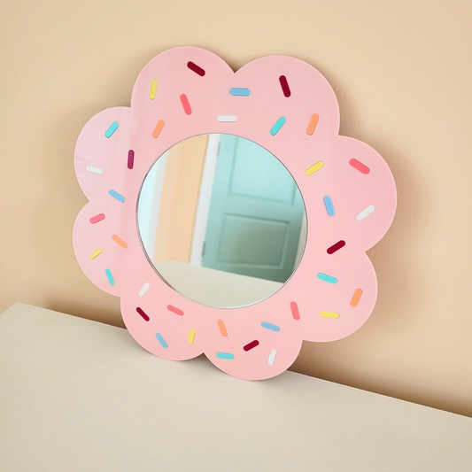 Pink donut-shaped acrylic wall mirror with colourful sprinkles and MDF backing. Fun dopamine decor piece for bedroom, vanity, or statement wall.