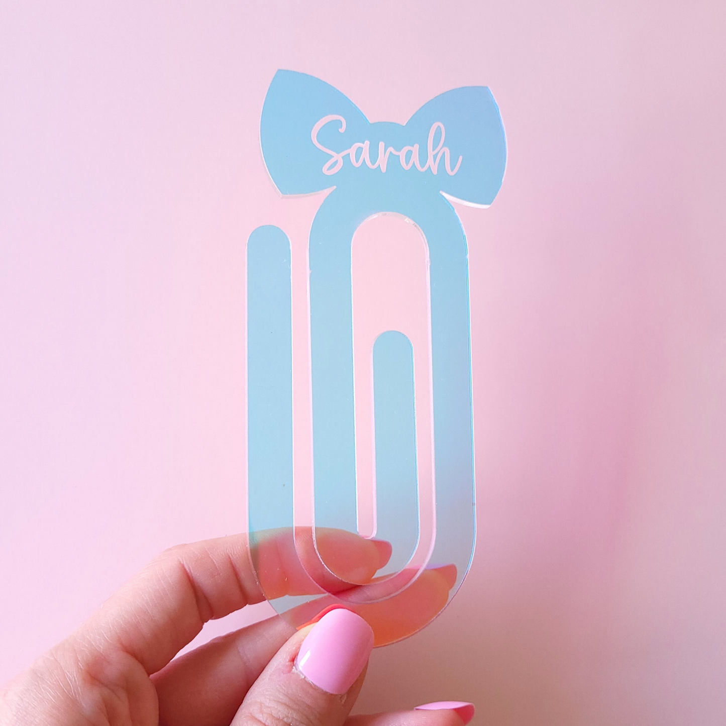 Iridescent girly acrylic bow bookmark with custom name Sarah on pastel background