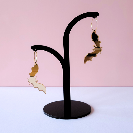 Gold mirror acrylic bat silhouette earrings on gold hoop, shiny gothic statement jewellery by Pop Heart Studio.