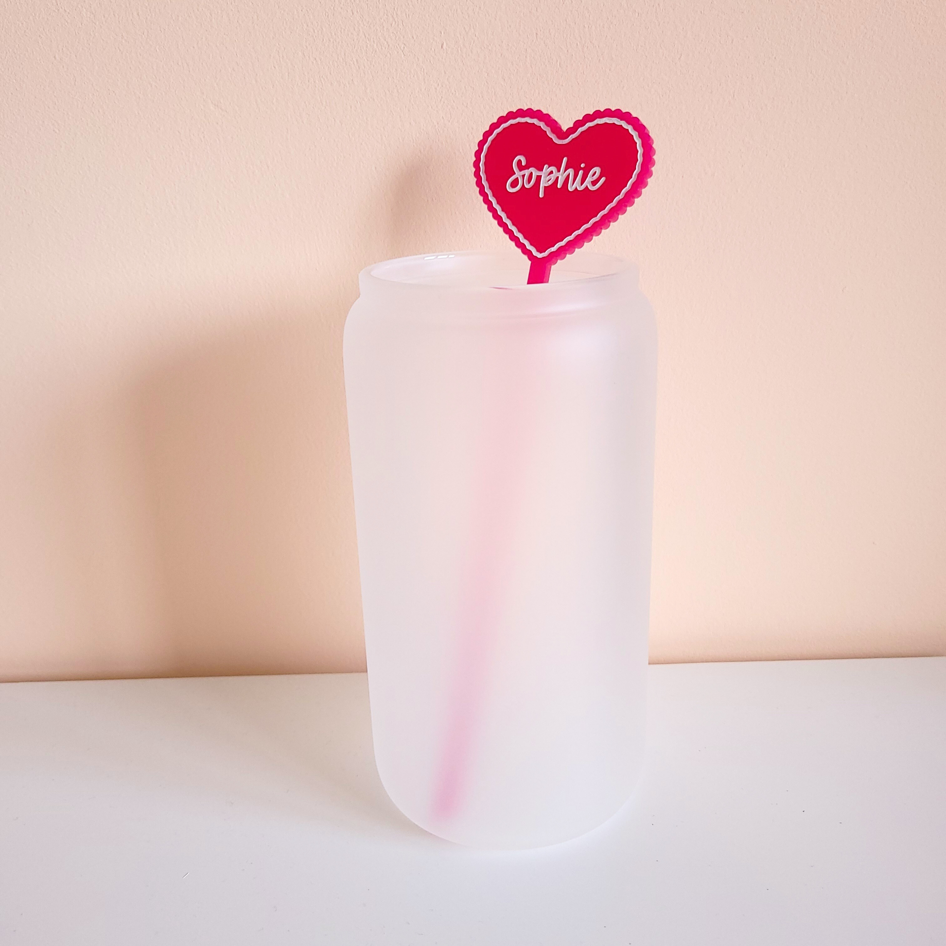 Personalised pink acrylic heart drink stirrer with name Sophie in a frosted glass cup