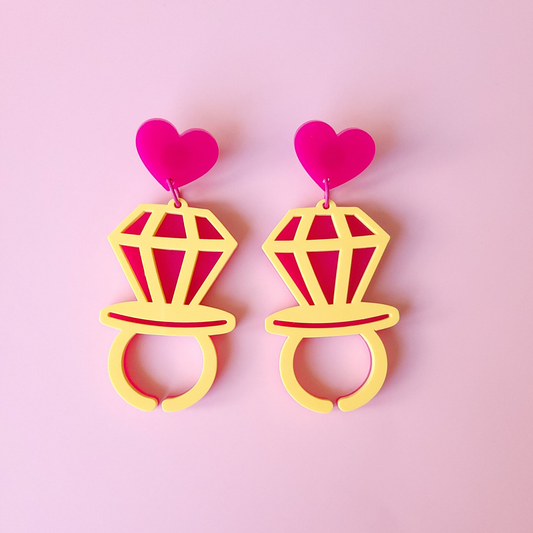 Pair of Heart Pop Earrings with heart-shaped tops  on a pink background