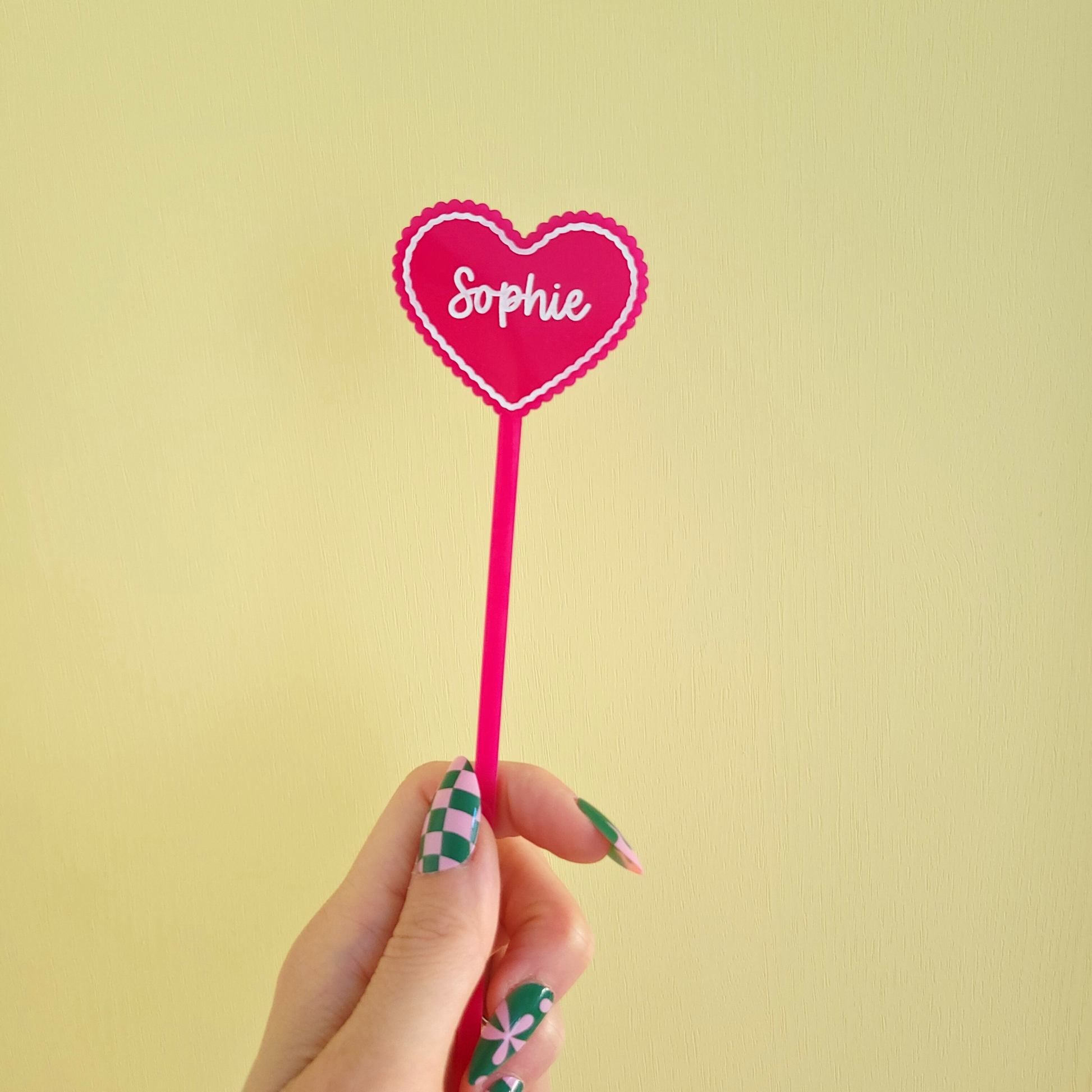 Custom heart-shaped drink stirrer in pink acrylic for cocktails and iced coffee