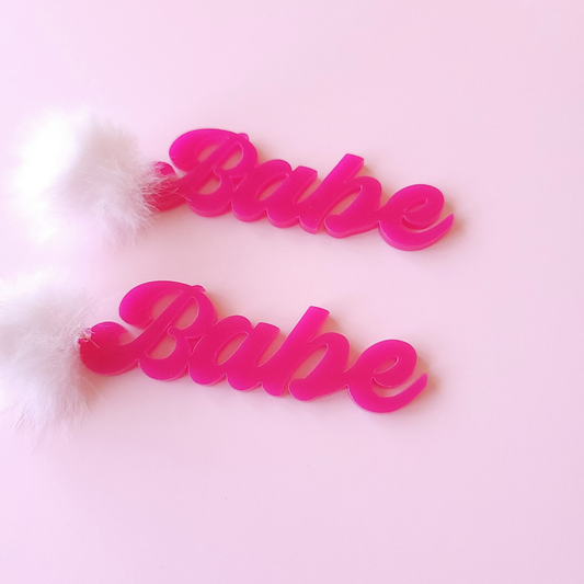 Hot pink 'Babe' earrings on a light pink background
