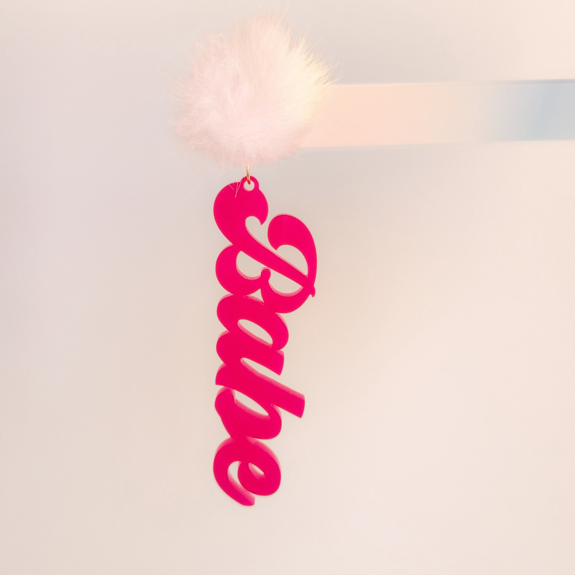Pink 'Babe' earring on a whitebackground