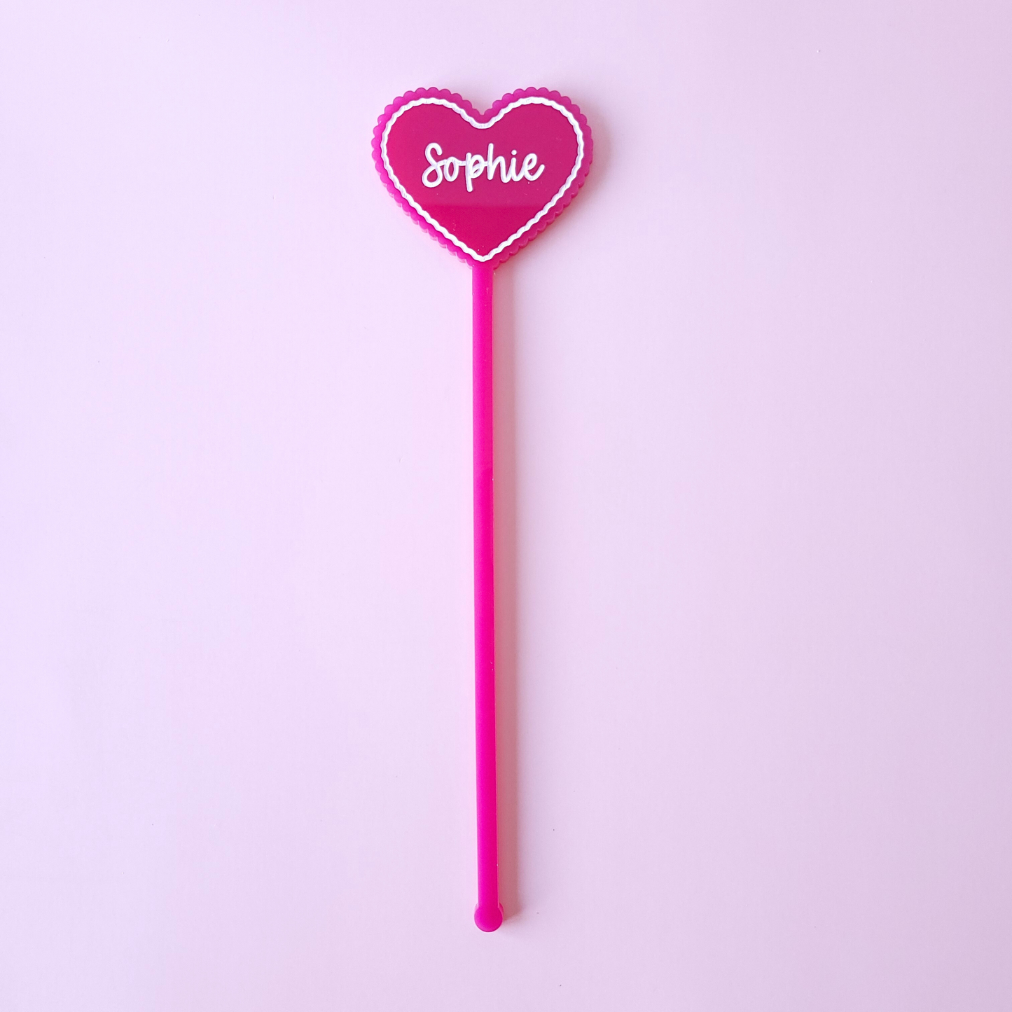 Personalised pink acrylic heart drink stirrer with name Sophie on pastel background