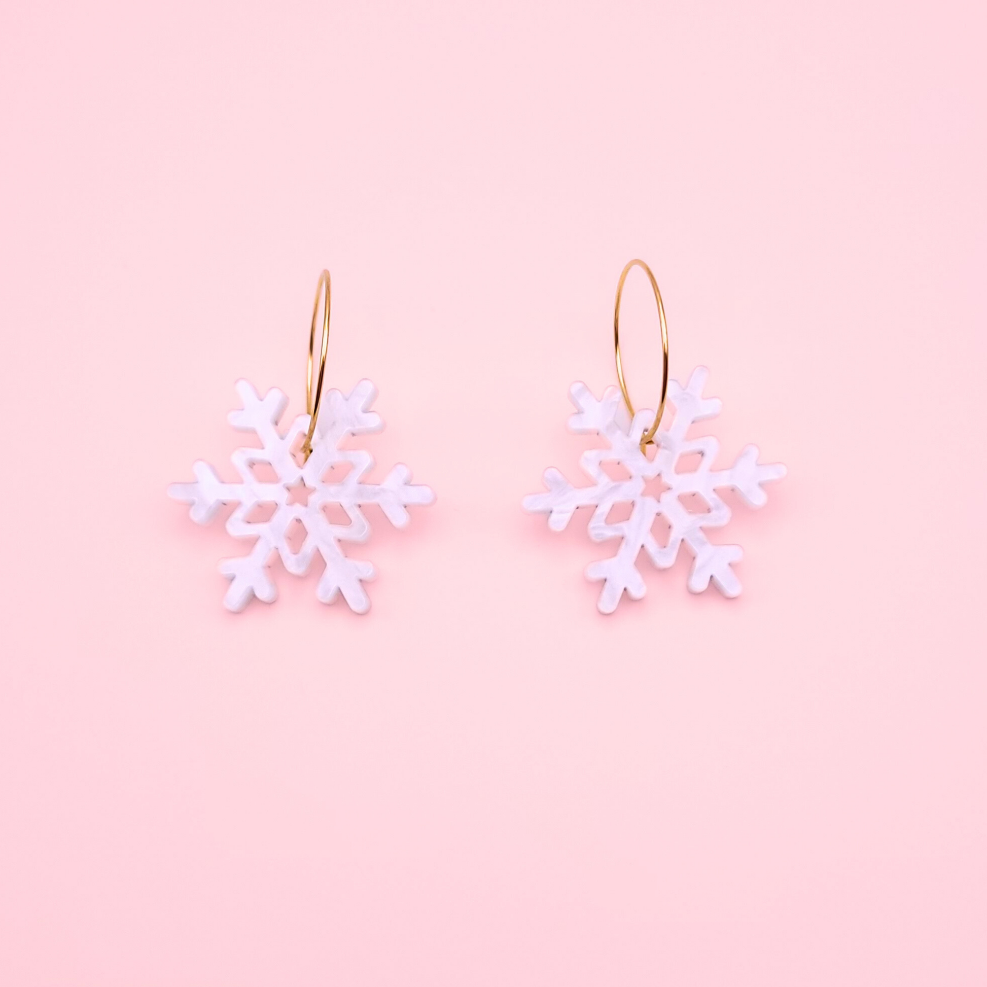 White marble acrylic snowflake earrings on gold hoops — handmade winter dangle earrings.